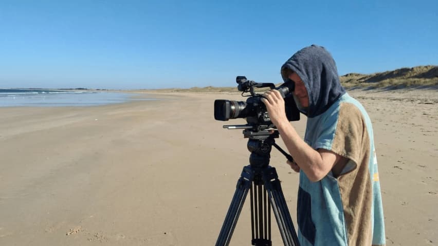 Un entraineur entrain de filmer depuis la plage
